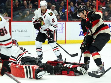 Curtis Lazar, right, of the Ottawa Senators follows the puck as goalie Scott Darling of the Chicago Blackhawks makes the save while #2 Duncan Keith and #88 Patrick Kane look on during first period NHL action.