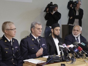 From left, Royal Canadian Mounted Police D.T. Critchley and Wayne Rideout, sit beside BC Muslim Association members Aasim Rashid and Musa Ismail during a media conference on Friday, Oct. 24, 2014 at the Burnaby, British Columbia mosque where the gunman who carried out an attack in Ottawa had previously prayed.