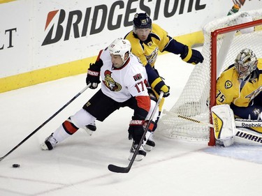 Ottawa Senators center David Legwand (17) brings the puck around the net as he is defended by Nashville Predators center Derek Roy (21) and goalie Pekka Rinne (35), of Finland, in the first period.