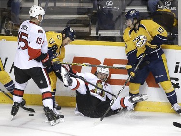 Ottawa Senators defenseman Erik Karlsson, of Sweden, falls to the ice as he fights for the puck with teammate Zack Smith (15) and Nashville Predators' Colin Wilson (33), Olli Jokinen (13), of Finland, and Calle Jarnkrok (19), of Sweden, in the second period.