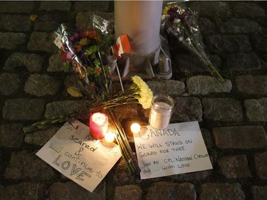 Flowers and candles left by mourners sit near the National War Memorial.