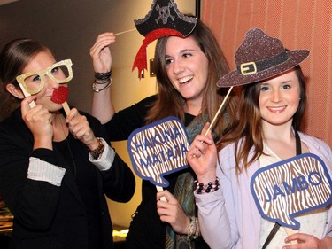 From left, Megan Lalonde, Kim Maloney and Kelsey Hunt pose with props at the MDRN Photobooth  at the inaugural HERA Mission charity gala in support of widows and orphans in western Kenya, co-hosted by the Ottawa Redblacks CFL team at the TD Place on Wednesday, Oct. 15, 2014.