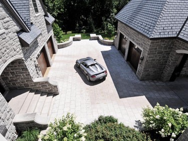 Designed by André Godin, the 15,000-square-foot stone home offers a vehicle courtyard, coach house and room for five cars.