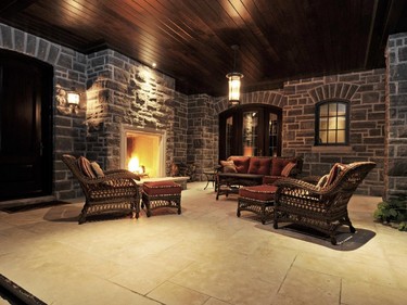 An outdoor covered sitting area is warmed by one of the home’s six fireplaces.