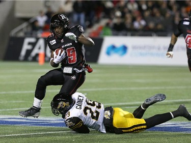 Running back Roy Finch #19 of the Ottawa Redblacks gets tackled by defensive back Ed Gainey #29 of the Hamilton Tiger-Cats in the second quarter.