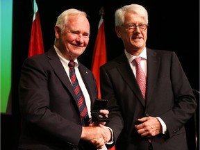 His Excellency the Right Honourable David Johnston, Governor General and Commander-in-Chief of Canada (L) receives a commemorative lapel pin to mark the 70th anniversary of the liberation of the Netherlands during the Second World War from His Excellency Cees Kole, Ambassador of the Kingdom of the Netherlands at the Canadian War Museum in Ottawa, October 16, 2014.