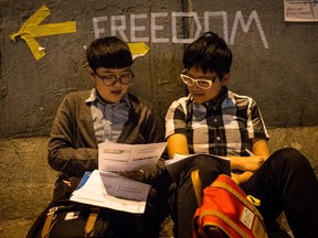 HONG KONG - OCTOBER 08: Two university students study accounting on the street outside Hong Kong's Government complex on October 8, 2014 in Hong Kong, Hong Kong. With many protesters returning to work and school, supporter numbers have dwindled leaving a small number defying the governments request to leave the area.