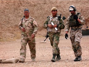 A German military expert (R) speaks with Kurdish Peshmerga leaders during training at a shooting range in Erbil, the capital of the Kurdish region of northern Iraq.