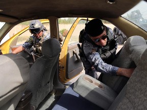 Iraqi federal policemen search a car at a checkpoint in Baghdad, Iraq, Saturday, Oct. 11, 2014. On the western edge of Iraq�s capital, Islamic State group militants battle government forces and exchange mortar fire, only adding to the sense of siege in Baghdad despite airstrikes by a U.S.-led coalition. Military experts say the Sunni militants, won�t be able to fight through both government forces and Shiite militias now massed around the capital, It does, however, put them in a position to wreak havoc in Iraq�s biggest city, with its suicide attacks and other assaults.