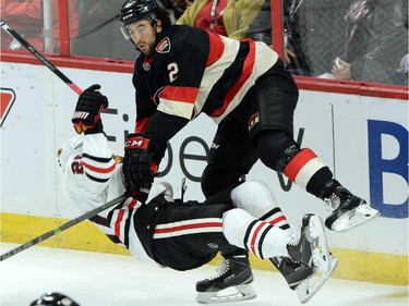 Ottawa Senators' Jared Cowen slams Chicago Blackhawks' Brandon Saad to the ice during first period NHL hockey action.