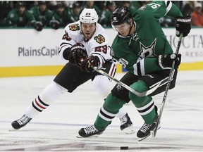 Dallas Stars forward Jason Spezza (90) battles Chicago Blackhawks forward Bryan Bickell (29) for space in the first period of an NHL hockey game, Thursday, Oct. 9, 2014, in Dallas.