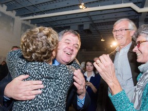 Jean Cloutier hugs a supporter at campaign HQ as he takes over from Peter Hume in Alta Vista ward Monday evening. (Michael Robinson/Ottawa Citizen)