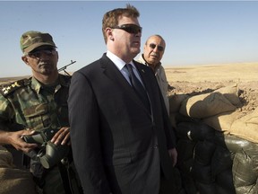 Canadian Foreign Affairs Minister John Baird, centre, and Iraqi Deputy Minister Rowsch Nouri Sharways look at the ISIS positions from a front line bunker Thursday, September 4, 2014 in Kalak, Iraq.
