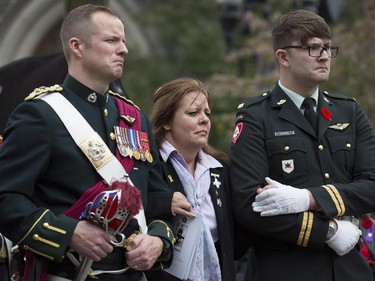 The mother of Cpl. Nathan Cirillo stands with two soldiers as her son's casket is loaded into the hearse following his funeral service.