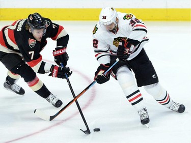 Ottawa Senators' Kyle Turris fights for the puck against Chicago Blackhawks' Michal Rozsival during first period NHL hockey action.