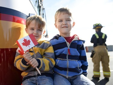 (L-R) Twins, Adam and Liam Riddell (3) with Canadian flag at Bankfield at the 416 to pay respects as the escort with the body of Nathan Cirillo is transported by hearse from Ottawa via Highway of Heroes to Hamilton on Friday, Oct. 24, 2014.