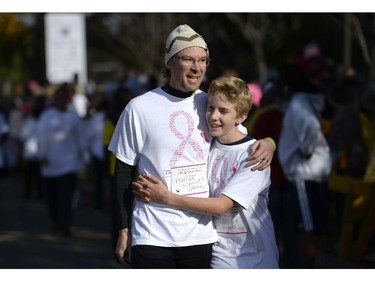 Leo Holton, 14, right, spends a moment with his father David Holton at the finish of the CIBC Run for the Cure in Ottawa on Sunday, October 5, 2014.