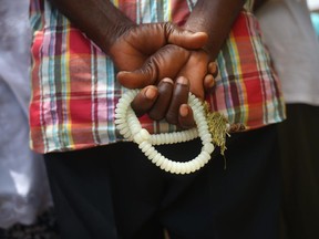 MONROVIA, LIBERIA - OCTOBER 10:  A Muslim man holds his prayer beads as an Ebola burial team arrives to collect the body of a neighbor on October 10, 2014 of Monrovia, Liberia. The World Health Organization says the Ebola epidemic has now killed more than 4,000 people in West Africa.