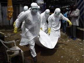 Red Cross workers carry away the body of a person suspected of dying from the Ebola virus, in the Liberian capital Monrovia, on October 4, 2014. By far the most deadly epidemic of Ebola on record has spread into five west African countries since the start of the year, infecting more than 7,000 people and killing about half of them.