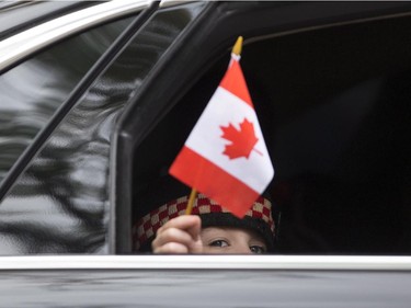 Marcus Cirillo, son of Cpl. Nathan Cirillo, waves a flag out of a car window following the funeral service for his father.