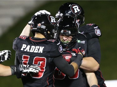 Matt Carter, middle, of the Ottawa Redblacks celebrates his touchdown with Khalil Paden, left, and Colin Kelly against the Hamilton Tiger-Cats during first half CFL action.