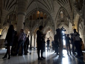 Members of the media stand in the Rotunda as they wait for caucus meetings to break Wednesday October 29, 2014 in Ottawa, one week after a shooter entered Parliament Hill.