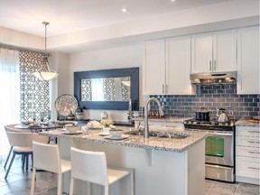 In the Galloway kitchen, white cabinets make a crisp contrast with a brown tile backsplash. The granite island and undermount sink are upgrades.