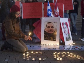Mourners take part in a vigil for slain soldiers Nathan Cirillo and Patrice Vincent Tuesday, October 28, 2014 in Montreal.