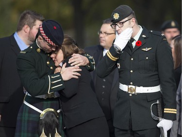 Kathy Cirillo, the mother of Cpl. Nathan Cirillo, is comforted by a soldier during a pause in the escort of her son's body through the streets toward his funeral service.