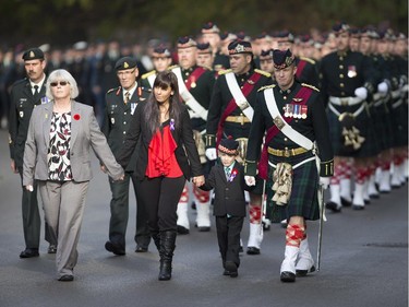 Marcus Cirillo walks with his aunt, Natasha as the body of Cpl. Nathan Cirillo is escorted through the streets toward his funeral service.