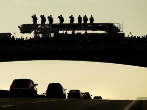 Supporters pay tribute as the remains of Cpl. Nathan Cirillo are transported from Ottawa to Hamilton, along the Highway of Heroes in Port Hope, Ont., on Friday.
