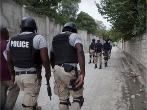 National police officers patrol outside the home of Haiti's former President Jean-Bertrand Aristide in Port-au-Prince, Haiti.