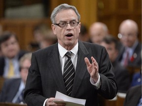 Finance Minister Joe Oliver answers a question during Question Period in the House of Commons on Parliament Hill in Ottawa, Monday, Oct. 27, 2014 . Oliver came under fire Wednesday over allegations his office broke federal rules by sole-sourcing a contract to the law firm of Prime Minister Stephen Harper's former chief of staff.