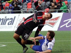 Ottawa Fury striker #28 Vini Dantas (left) falls awkwardly during NASL soccer action at TD Place in Ottawa, Saturday, October 18, 2014.