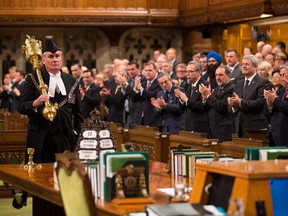 Sergeant-at-Arms Kevin Vickers enters the House of Commons Thursday to a standing ovation from all the MPs, one day after he helped kill an armed attacker in the Centre Block.