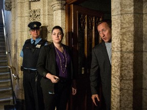 Justice Minister Peter MacKay, right,  talks to reporters at the entrance to the House of Commons, a day after the attack in Ottawa.