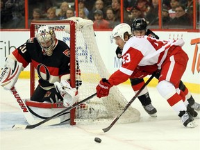 Goalie Andrew Hammond is in position to stop Darren Helm being chased by Jason Spezza in the 2nd period as the Ottawa Senators take on the Detroit Red Wings in NHL action at Canadian Tire Centre.