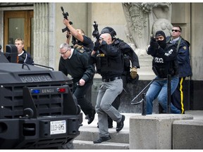Ottawa Police and RCMP remove a member of the military from an exit behind the Canada Post building on Sparks street Wednesday October 22, 2014.   ( Ashley Fraser / Ottawa Citizen )