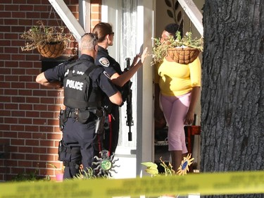 Ottawa Police officers go door to door after a shooting near Iris Street on Friday, October 3, 2014.
