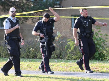 Ottawa Police officers patrol an area where an apparent shooting incident took place near Iris Street on Friday, October 3, 2014.