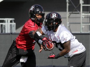 Ottawa RedBlacks QB Henry Burris hands off to running back Jeremiah Johnson (27) during a drill at practice today at TD Place in Ottawa, Monday, October 27, 2014. The RedBlacks take on Hamilton Tiger-Cats this Friday at TD Place.