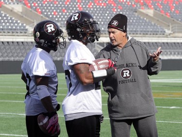 Ottawa RedBlacks running backs coach Don Yanowsky instructs Roy Finch (left, 19) and Jeremiah Johnson (27) during practice today at TD Place in Ottawa, Monday, October 27, 2014. The RedBlacks take on Hamilton Tiger-Cats this Friday at TD Place.