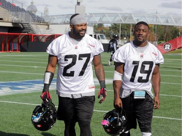 Ottawa RedBlacks running backs (L2R) Jeremiah Johnson (27) and Roy Finch (19) take a breather after practice today at TD Place in Ottawa, Monday, October 27, 2014. The RedBlacks take on Hamilton Tiger-Cats this Friday at TD Place.