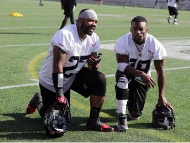 Ottawa RedBlacks running backs (L2R) Jeremiah Johnson (27) and Roy Finch (19) take a breather after practice today at TD Place in Ottawa, Monday, October 27, 2014. The RedBlacks take on Hamilton Tiger-Cats this Friday at TD Place.