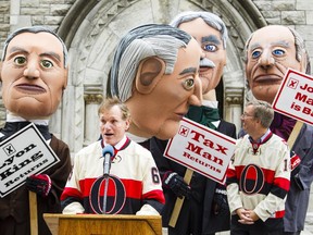 Ottawa Senators' President, Cyril Leeder, left, speaks while Ottawa Mayor Jim Watson, right, takes a look at some larger-than-life figures during a press conference outside the Heritage Building on Elgin St. Thursday October 9, 2014 where the Ottawa Senators unveiled a new component to the club's game-night oplans for the upcoming season. The plan involves large figurines depicting some of Canada's most famous prime ministers, Sir Robert Borden, Sir John A. Macdonald, Sir Wilfrid Laurier and William Lyon Mackenzie King.  (Darren Brown/Ottawa Citizen)