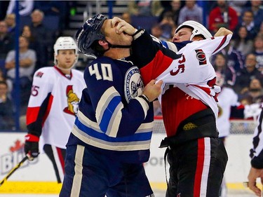 Chris Neil #25 of the Ottawa Senators gouges the eyes of Jared Boll #40 of the Columbus Blue Jackets during a fight in the first period.