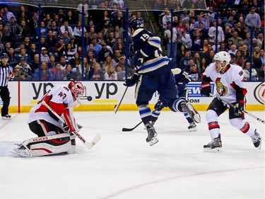 Ryan Johansen #19 of the Columbus Blue Jackets leaps in the air in an attempt to screen the puck as Robin Lehner #40 of the Ottawa Senators stops the shot from Scott Hartnell #43 of the Columbus Blue Jackets during the second period.