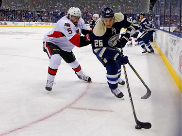 Corey Tropp #26 of the Columbus Blue Jackets and Cody Ceci #5 of the Ottawa Senators battle for control of the puck during the second period.