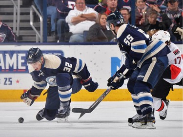 Adam Cracknell #32 of the Columbus Blue Jackets swats the puck out of the zone during the third period.