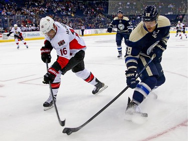 Clarke MacArthur #16 of the Ottawa Senators and David Savard #58 of the Columbus Blue Jackets battle for control of the puck during the third period.